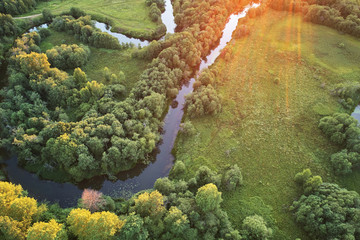 Forest with a winding river at sunset. Aerial photography with a drone.