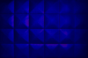 Background consists of large dark blue squares. Unusual, beautiful and modern background. Rhombic dark blue color wall of big squares.