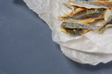 Salted fish lies in unfolded paper.