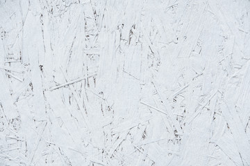 Abstract background. Oriental chipboard is painted with white paint. Visible glued wood chips.