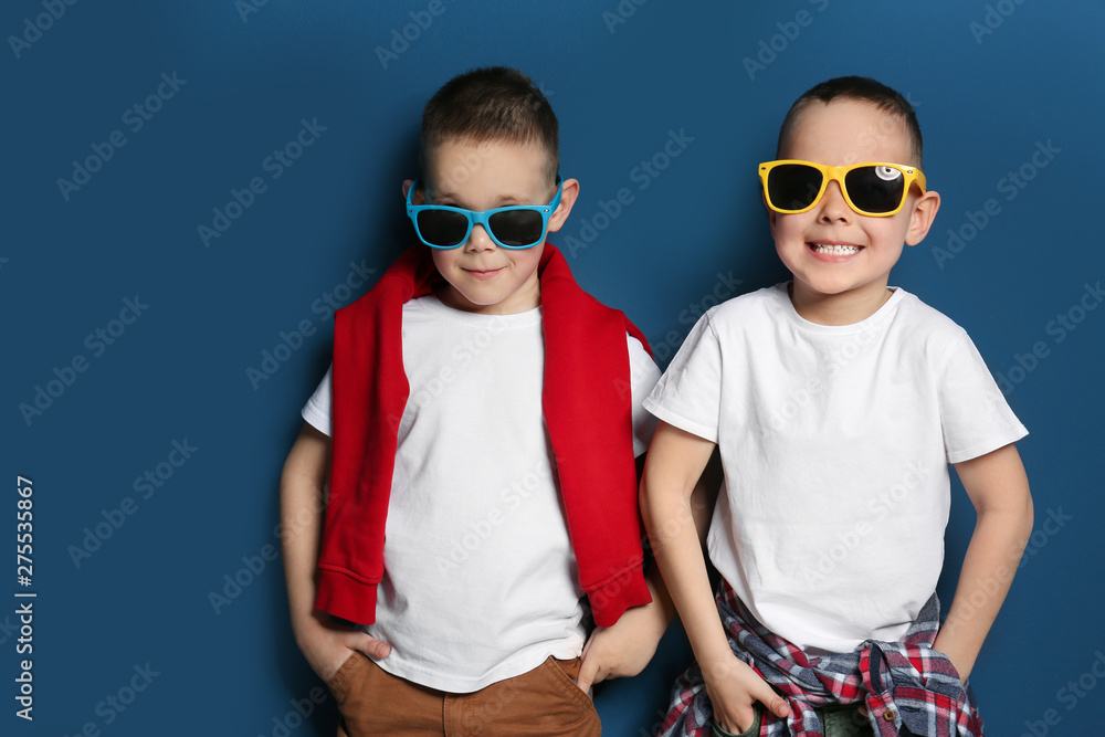 Sticker portrait of cute twin brothers with sunglasses on color background