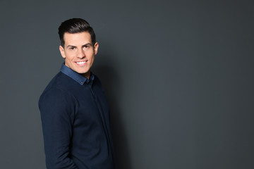 Fototapeta premium Portrait of handsome man smiling on grey background. Space for text