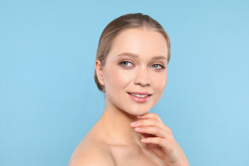 Fototapeta premium Portrait of young woman with beautiful face on blue background