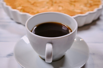 Apple pie and cup of coffee on a white background. Homemade cakes of ripe apples. Fruit cake in a white wooden background.