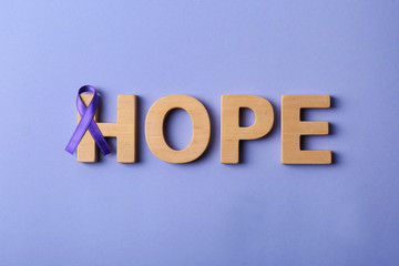 Flat lay composition with purple ribbon and word HOPE on violet background. Domestic violence awareness