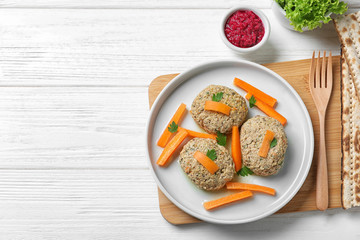 Flat lay composition with plate of traditional Passover (Pesach) gefilte fish on wooden background. Space for text