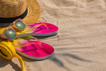 Different beach accessories on sand, space for text. Summer vacation