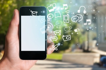 Hand holding smartphone  on a natural background with media illustration