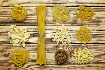 Collection of italian pasta top view on vintage wooden background.