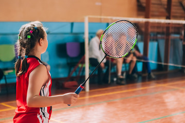 Badminton court with players. Tennis player with a racket. Badminton activity. Sports game of success. Happy kid playing badminton. The child beats the shuttle with a racket. - obrazy, fototapety, plakaty