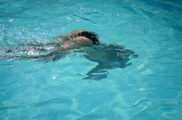 Obraz premium Young woman swimming underwater in swimming pool.