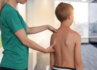 Child having chiropractic back adjustment. Osteopathy, Physiotherapy, Kinesiology. Bad posture...
