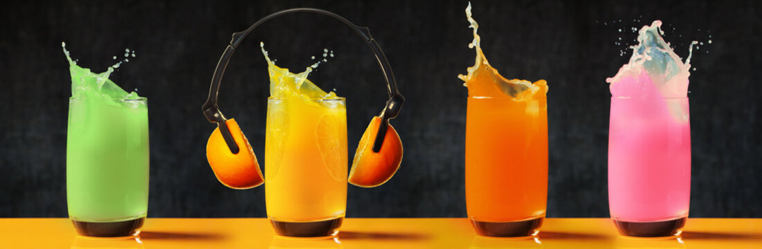 Multicolored glasses of juse with splash and headphone