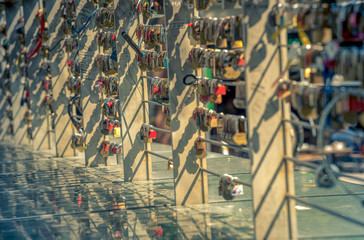 locks with a heart and a lot of other locks on the bridge with reflection
