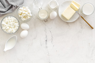 Fototapeta na wymiar Eggs, butter, milk, yougurt, cottage for natural farm products yougurt marble background top view monochrome copyspace