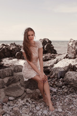 young woman in white lace dress relax on the beach