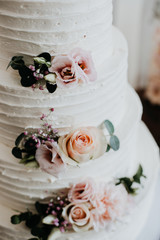 Detailaufnahme einer Hochzeitstorte im Vintage-Stil weiß mit Rosen verziert 