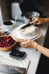Girl baker prepares a delicious berries cheesecake