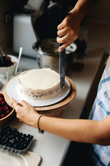 Girl baker prepares a delicious berries cheesecake