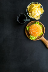 Traditional american food concept with burger on pan and drink on black background top view space for text