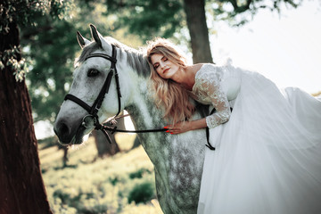 Obraz premium Beautiful and stunning bride, riding a horse in the nature