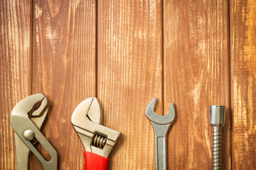 Necessary set of tools for plumbers on a vintage wooden wooden background.