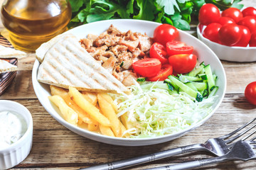 Greek gyros platter with french fries and vegetables.
