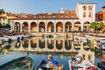 old harbour full of boats in Desenzano del Garda. Brescia, Lombardy, Italy. City Centre of...