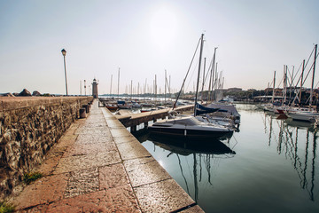 Fototapeta premium old harbour full of boats in Desenzano del Garda. Brescia, Lombardy, Italy. City Centre of Desenzano del Garda. marina on Lake Garda.