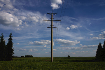 Fototapeta na wymiar Summer landscape with plowed field and power line poles