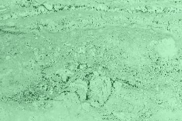 Closeup of trendy low contrast mint colored porous stone textured wall. Abstract color nature...