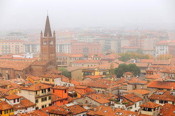 Fototapeta premium View on the old town Verona in aerial view, Italy. Fog above in Verona. red roofs of a medieval city in Italy