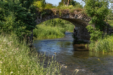 Fototapeta na wymiar Stone bridge crosses a stream