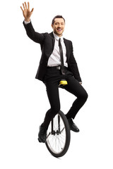 Young man in a suit riding a unicycle and waving at the camera © Ljupco Smokovski