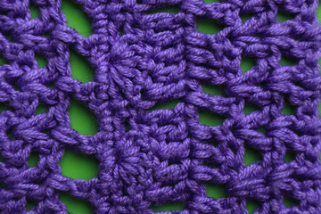 Knitted cloth on green background, close up