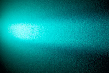 Bright light turquoise ray of light on a textural turquoise background