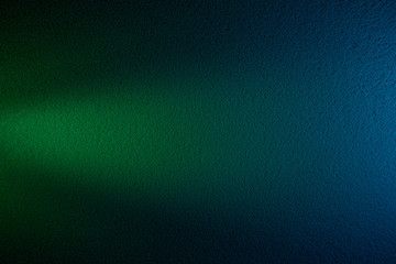 Green cone-shaped beam of light on a dark green and blue background