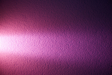 Pink narrow beam of light on a textural dark pink background