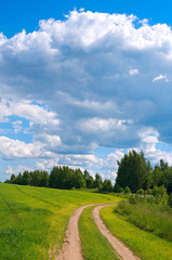  Summer landscape of green field and fluffy clouds.