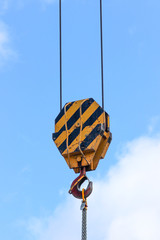 Fototapeta premium Closeup of the old lifting hook attached to sheave suspended by wire rope from boom of crane