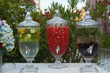 Fresh fruit and vegetable drink in a glass pitcher with tap, close-up
