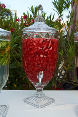 Fresh fruit and vegetable drink in a glass pitcher with tap, close-up