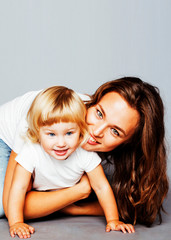 young pretty stylish mother with little cute blond daughter hugging, happy smiling real family, lifestyle people concept