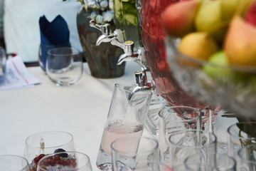 Fresh fruit and vegetable drink in a glass pitcher with tap, close-up
