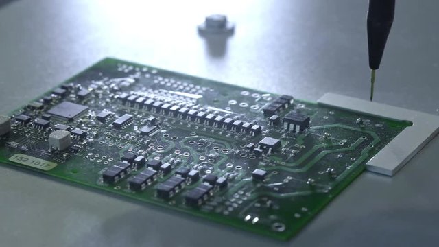 Mechanical creation process of electronic circuits. Creating an electronic board. Metal needle sets the chips on a plastic backing. Solders electronic components