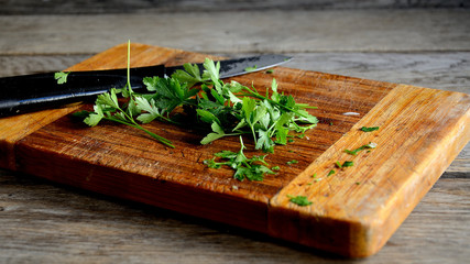 Parsley sliced on a kitchen board and a knife.