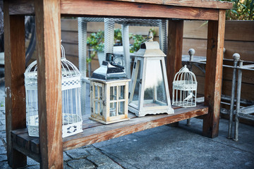 Fototapeta na wymiar Romantic decor metal bird cages and lanterns. Shby chic style.