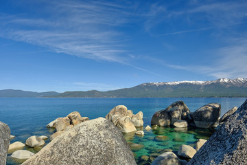 Large granite boulders ring the shoreline of he pristine and clear waters of Lake Tahoe