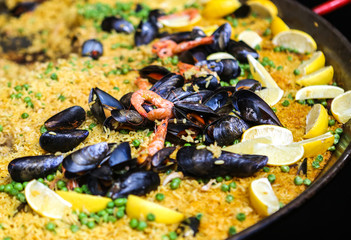 Paella a big platter of rice with mussels and shrimp. 