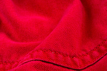 Fototapeta na wymiar clothing items stonewashed red cotton fabric texture with seams, clasps, buttons and rivets, macro